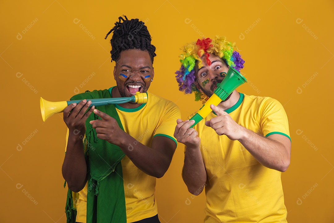 Homens brasileiros vestidos com camisetas do Brasil segurando acessórios de torcidas