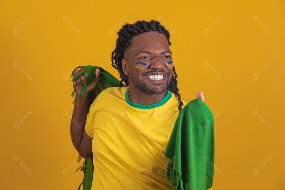Homem brasileiro vestindo uma camiseta do Brasil e segurando a bandeira nacional