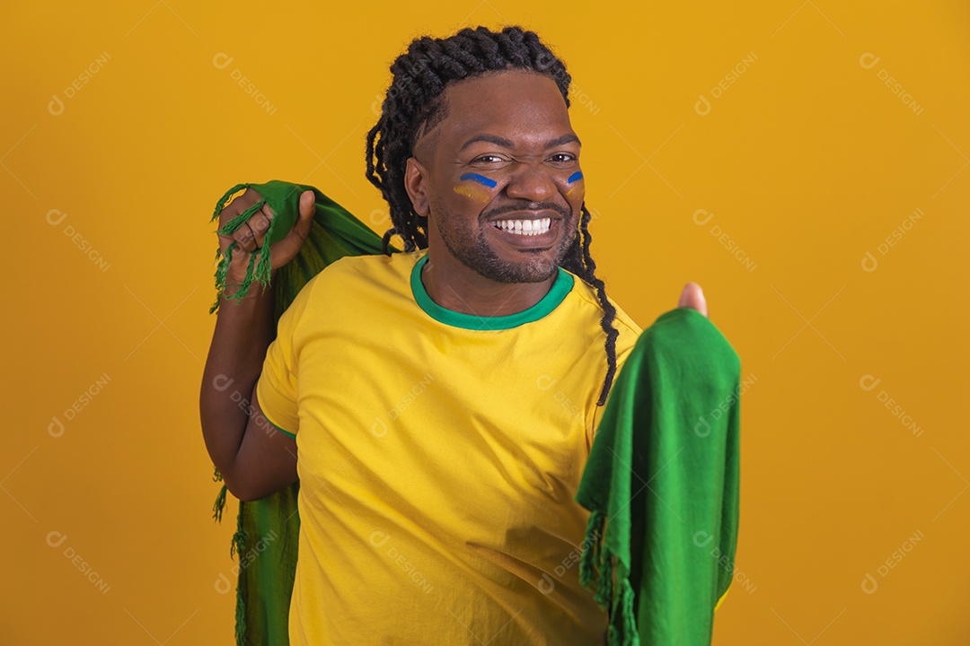 Homem brasileiro vestindo uma camiseta do Brasil e segurando a bandeira nacional