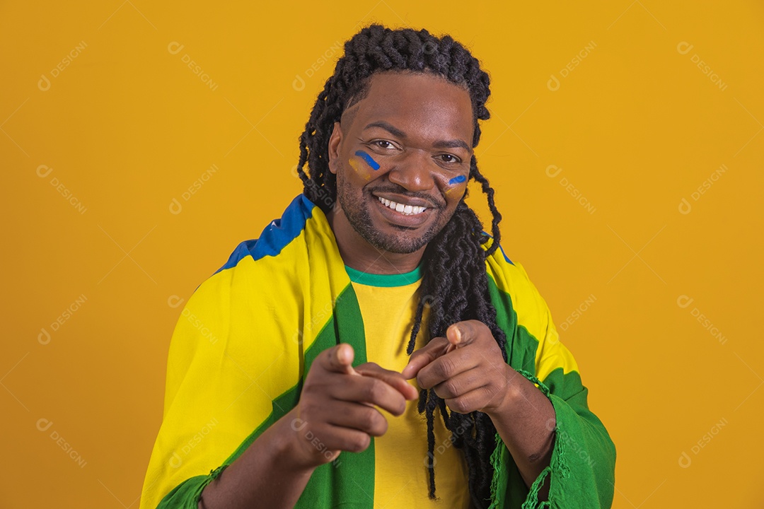 Homem brasileiro vestindo uma camiseta do Brasil e segurando a bandeira nacional
