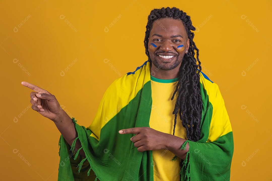 Homem brasileiro vestindo uma camiseta do Brasil e segurando a bandeira nacional