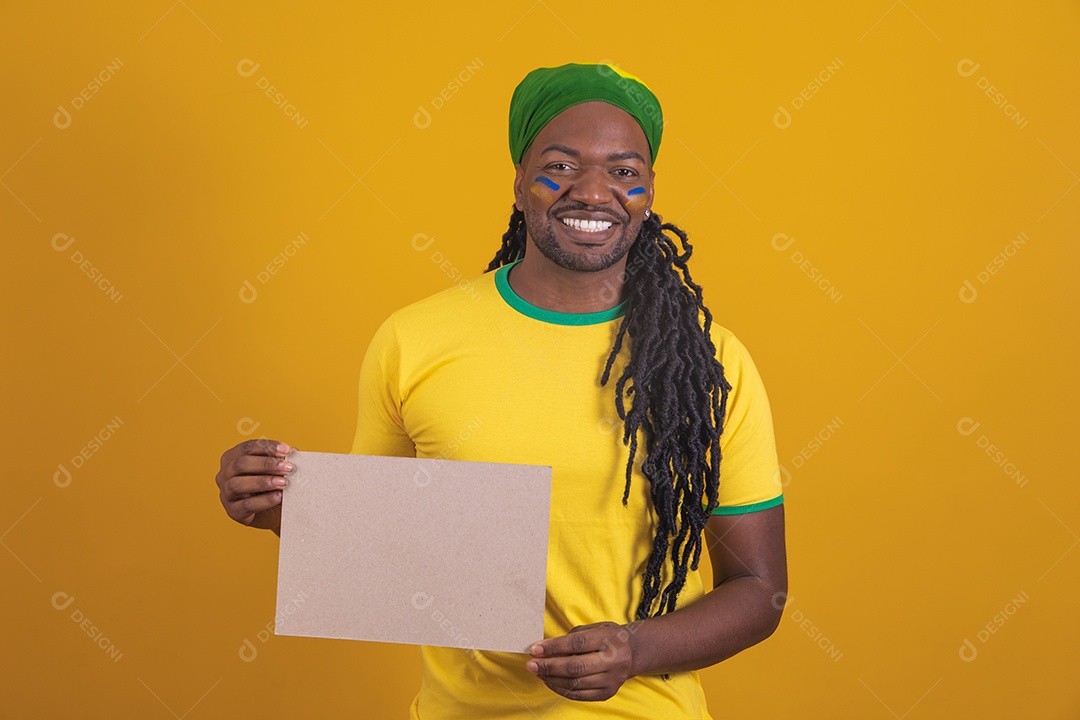 Homem brasileiro vestindo uma camiseta do Brasil segurando um papel em branco