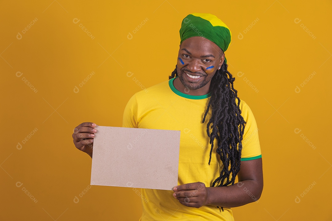 Homem brasileiro vestindo uma camiseta do Brasil segurando um papel em branco