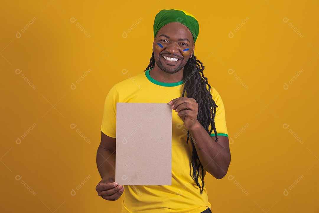 Homem brasileiro vestindo uma camiseta do Brasil segurando um papel em branco