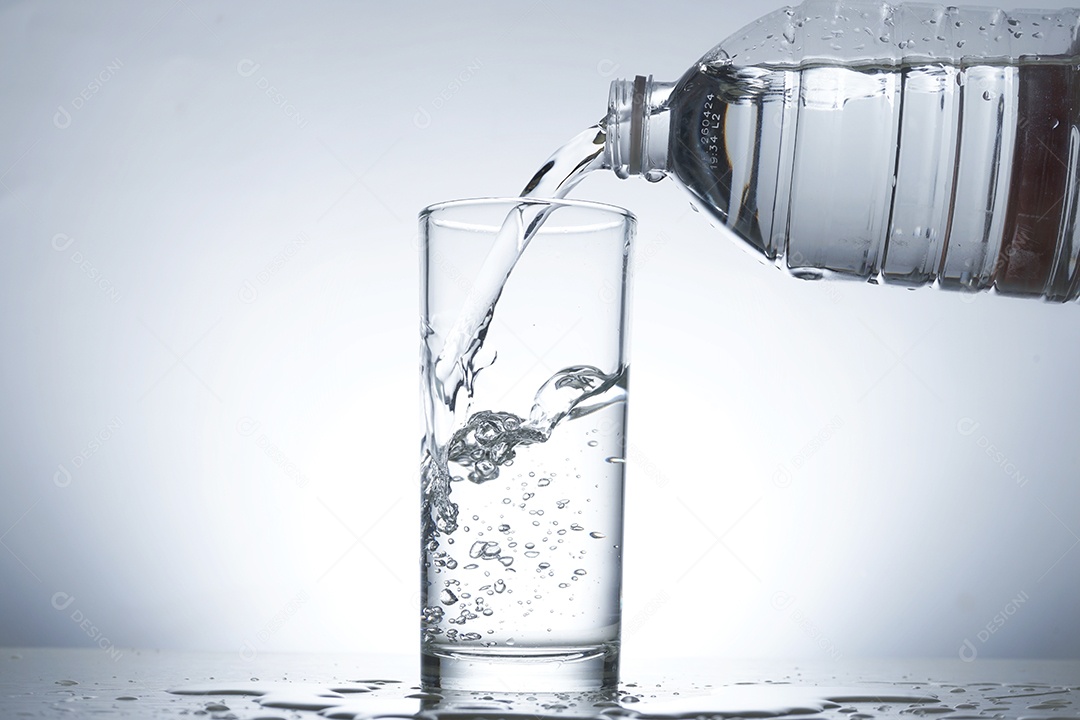 Garrafa colocando água no copo.