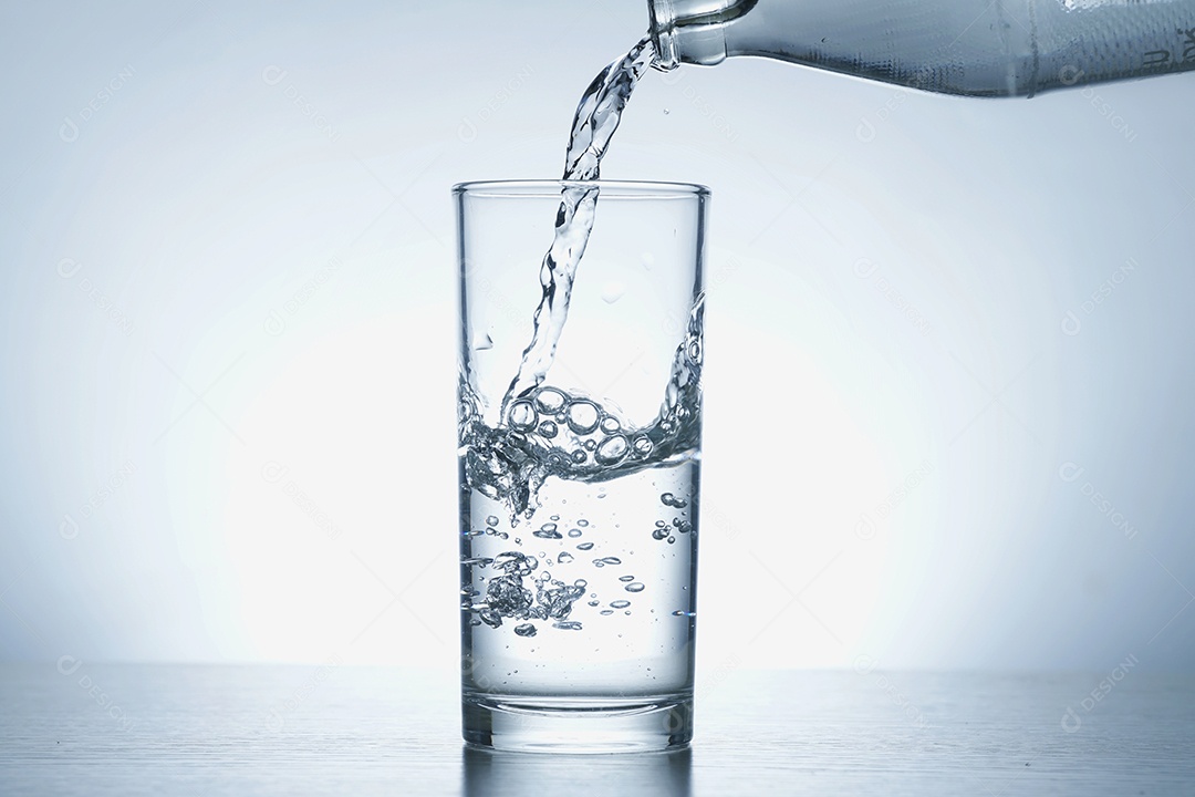 Garrafa colocando água no copo.