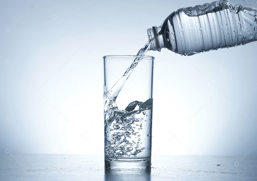 Garrafa de água com copo de vidro.