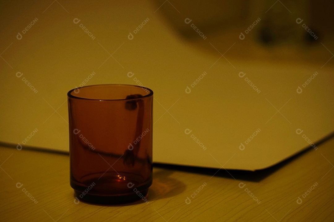 Uma xícara de vidro sobre uma mesa.