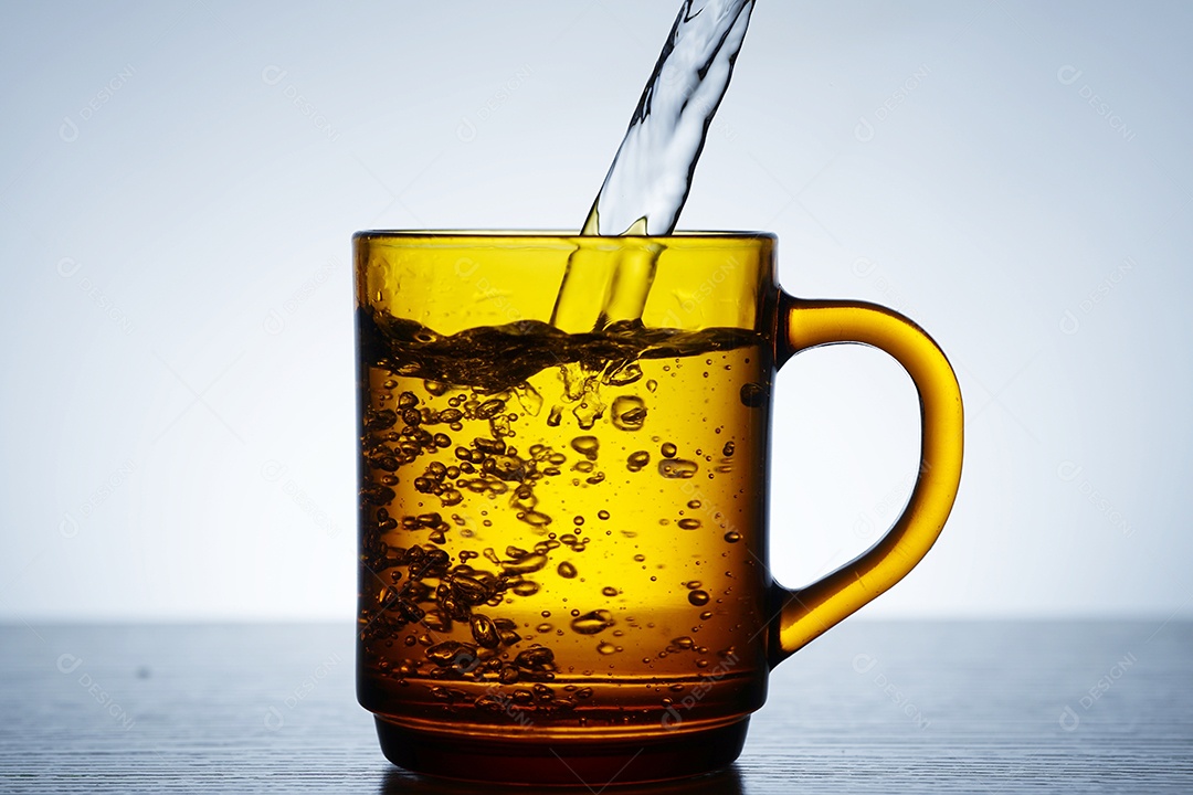 Xícara amarela com água.