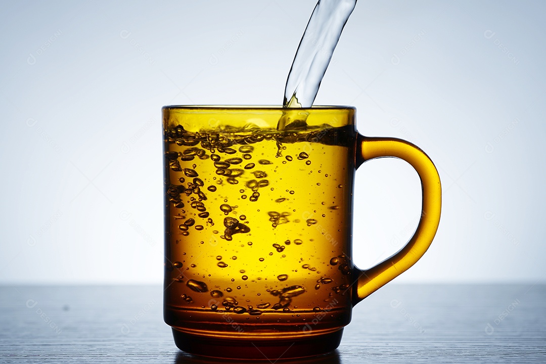 Xícara amarela com água.