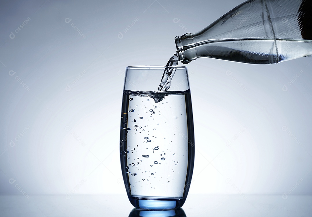 Pessoa colocando água dentro de um copo.