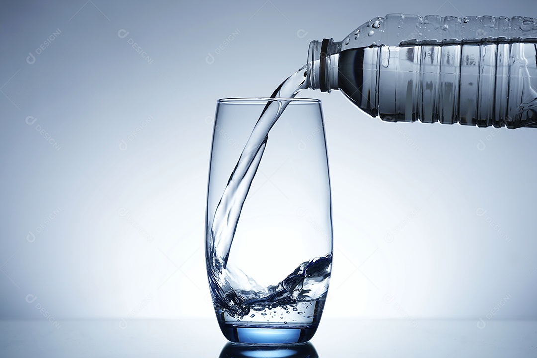 Pessoa colocando água dentro de um copo.