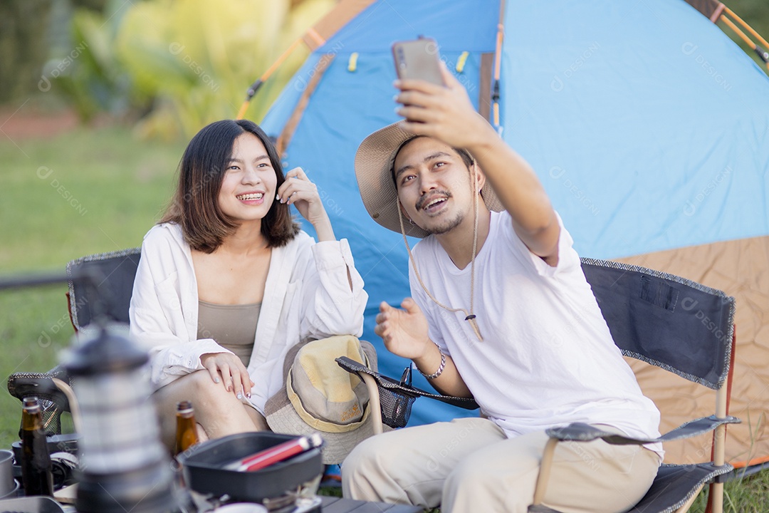 Casal asiático feliz toca guitarra e canta, gosta de acampar e beber cerveja.