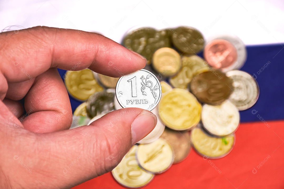 Moeda de rublo de prata na mão com pilha de moedas