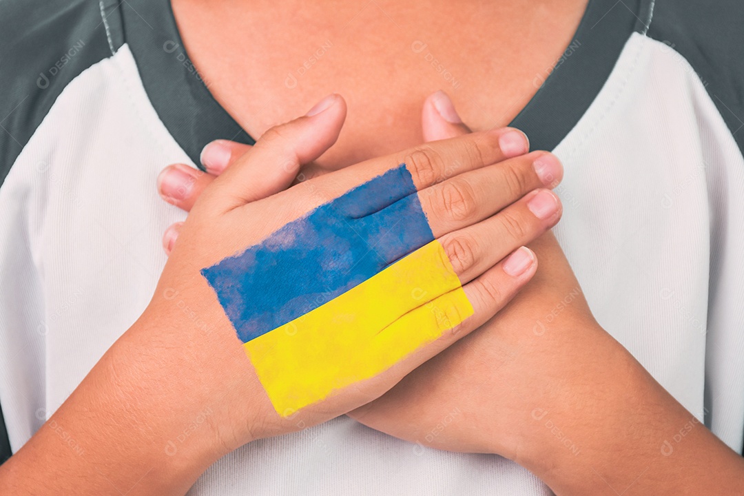 Um garoto apertou o peito para rezar e a bandeira ucraniana