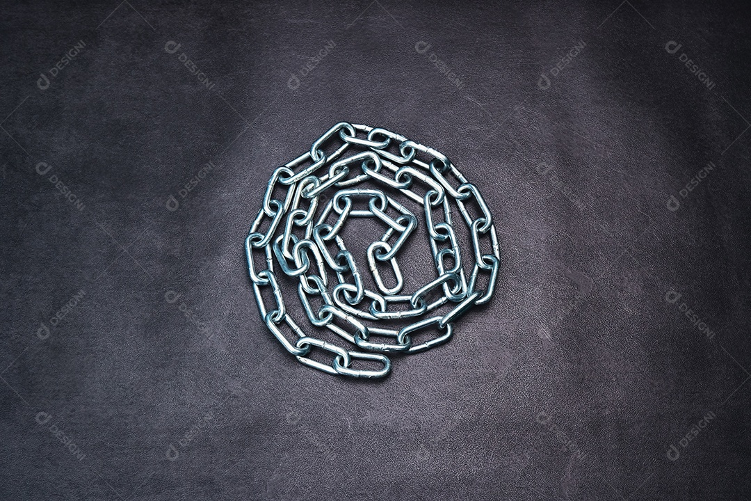 Uma corrente de metal enrolada em um círculo no chão de cimento
