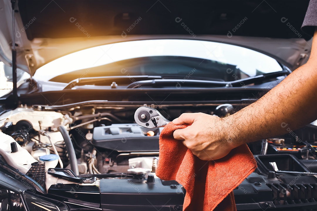Mão do mecânico de automóveis segurando a chave e pano vermelho para reparar o carro
