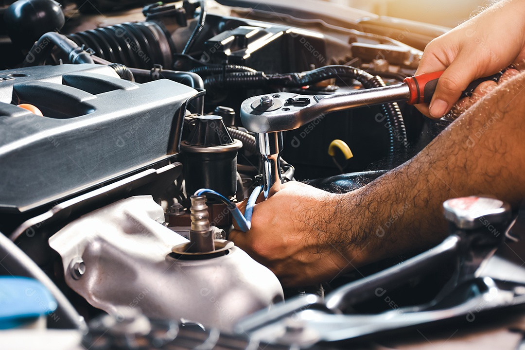 O mecânico de automóveis está consertando o motor do carro com um soquete