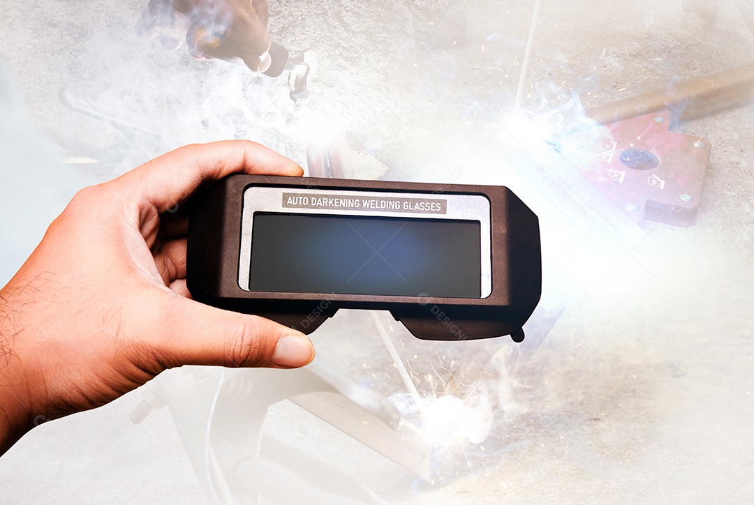 Vidros de soldagem de escurecimento automático na mão mecânica com um soldador