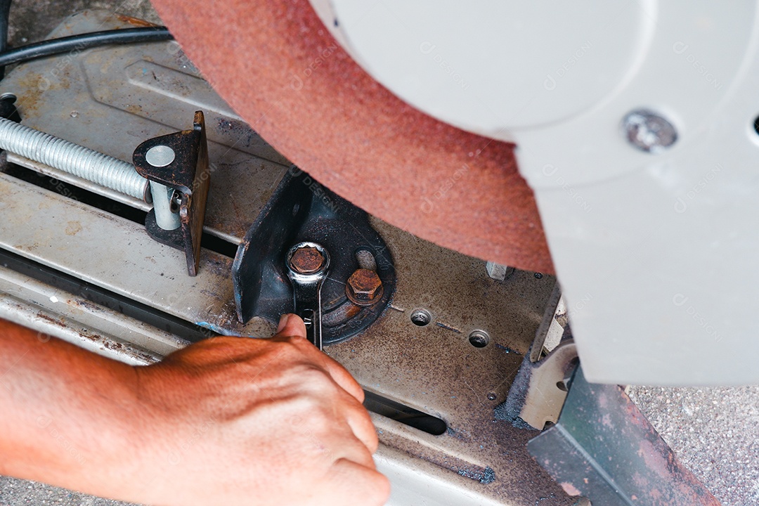 O técnico está apertando a porca para ajustar o ângulo de corte