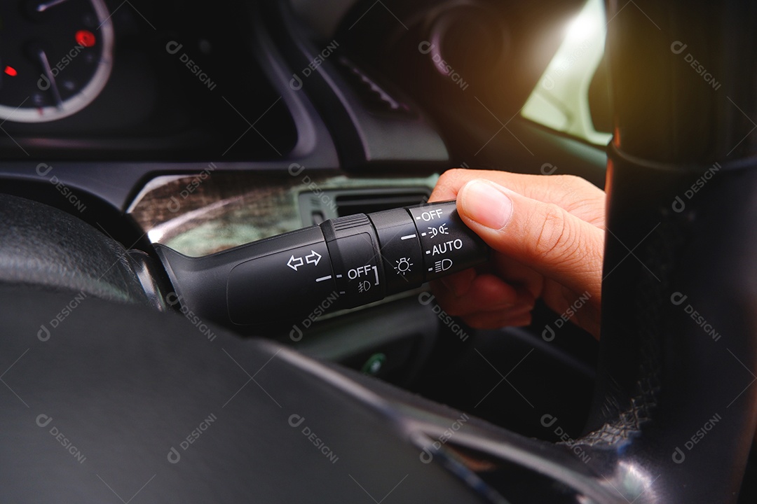A mão do motorista liga a alavanca do interruptor do farol