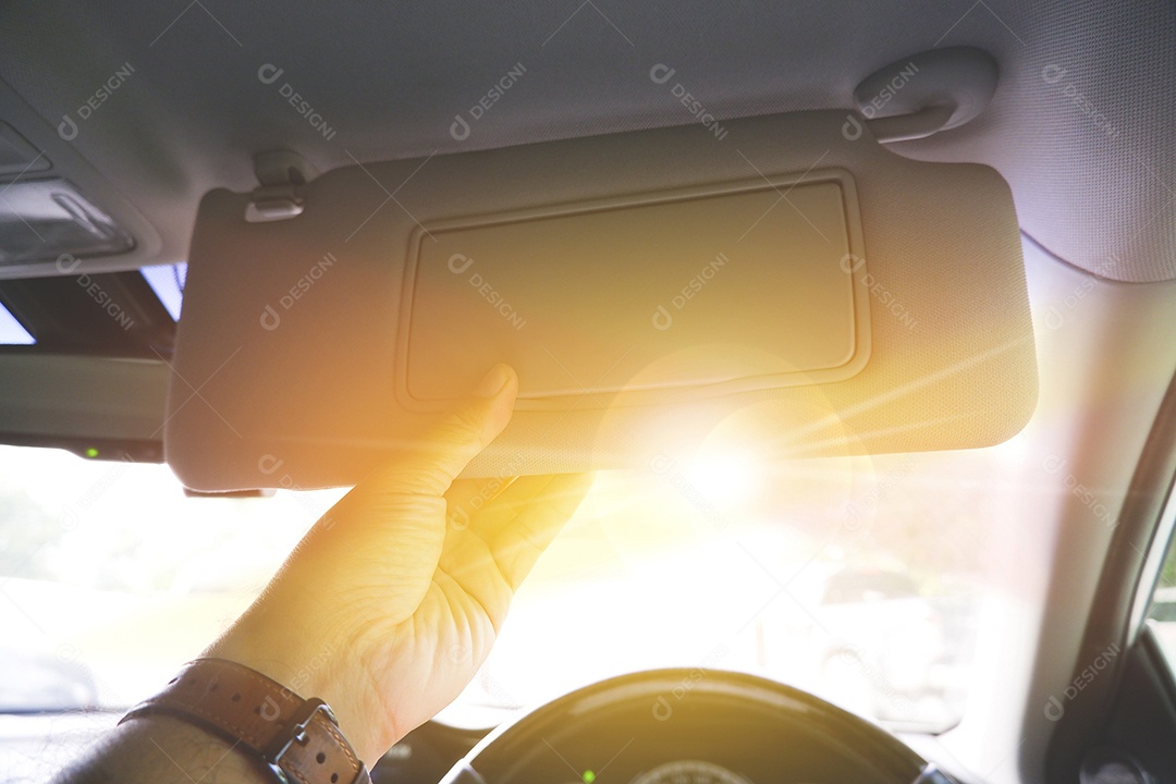 Motorista ajustando manualmente o para-sol para bloquear a luz solar