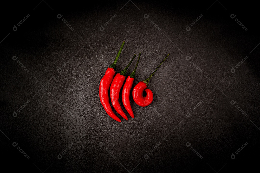Red hot chilli peppers empilhados sobre um fundo cinza escuro