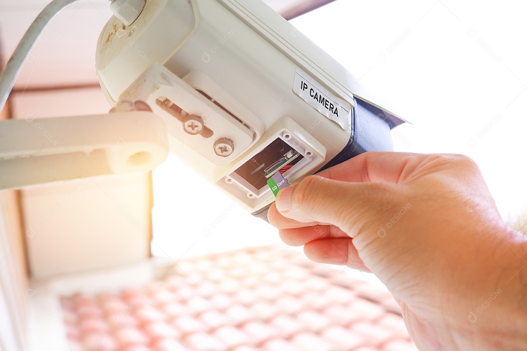 Cartão Micro SD sendo inserido na câmera CCTV IP pelo técnico