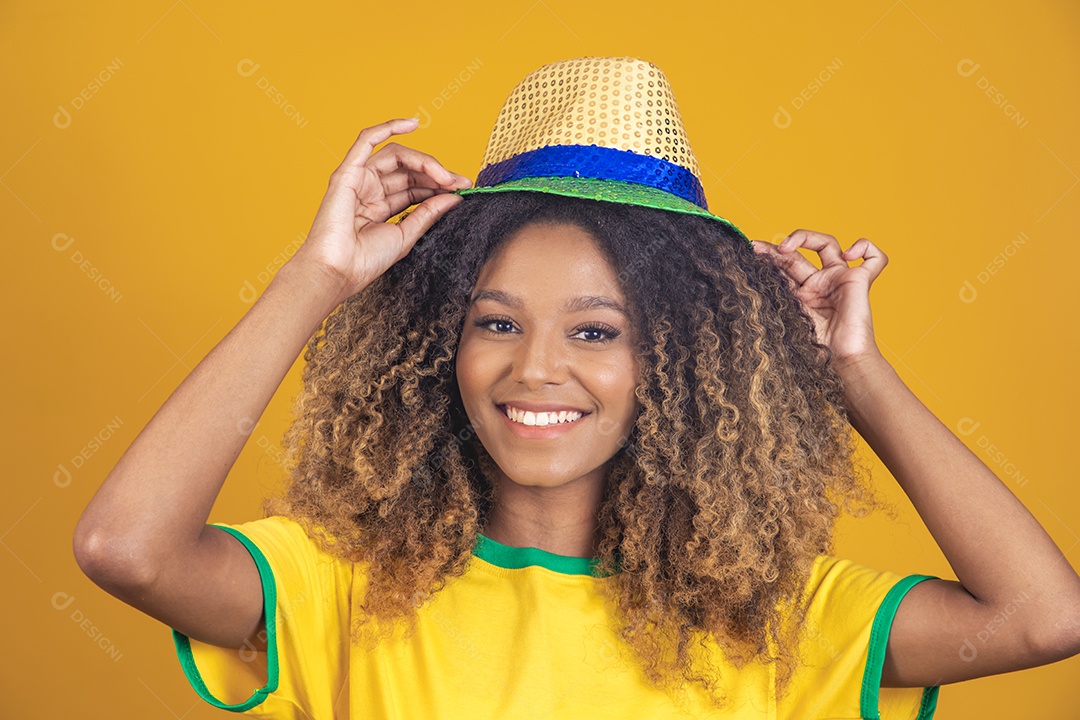 Mulher afro-brasileira vestindo camiseta do Brasil e usando um chapéu