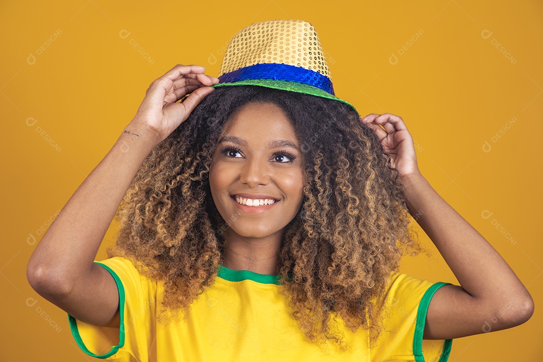 Mulher afro-brasileira vestindo camiseta do Brasil e usando um chapéu