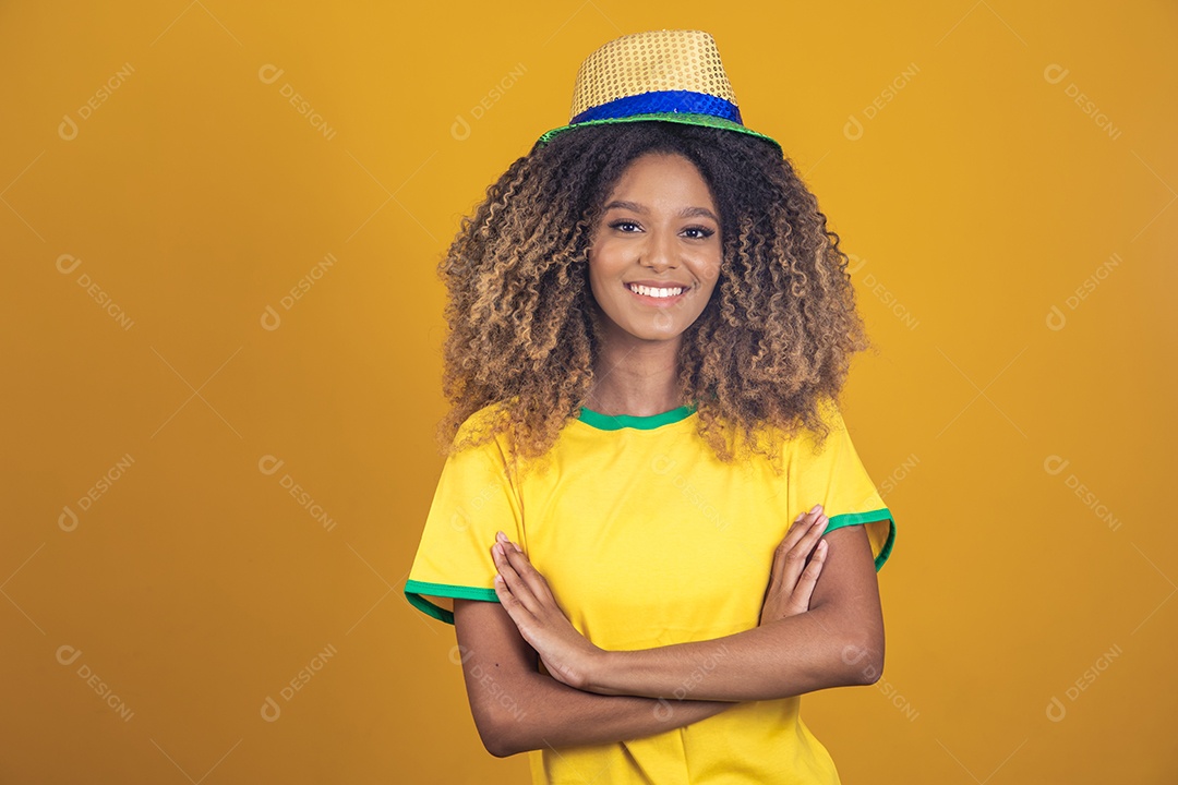 Mulher afro-brasileira vestindo camiseta do Brasil e usando um chapéu
