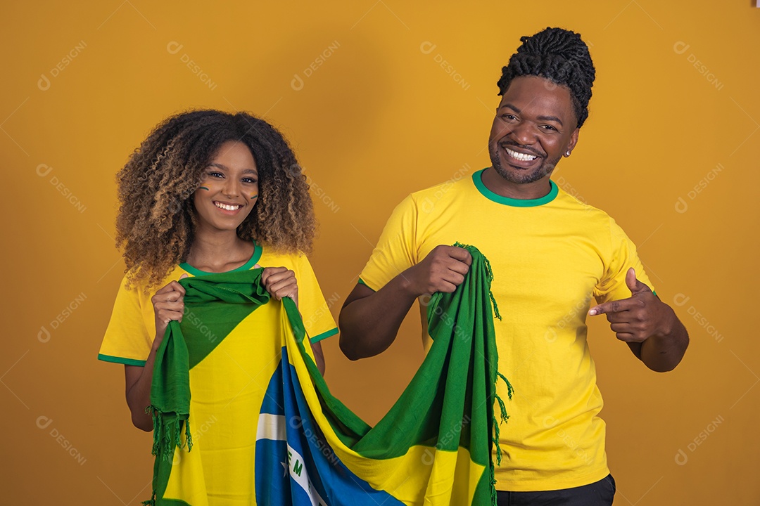 Casal afro-brasileiro segurando a bandeira do Brasil