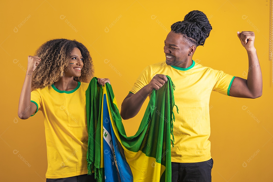 Casal afro-brasileiro segurando a bandeira do Brasil