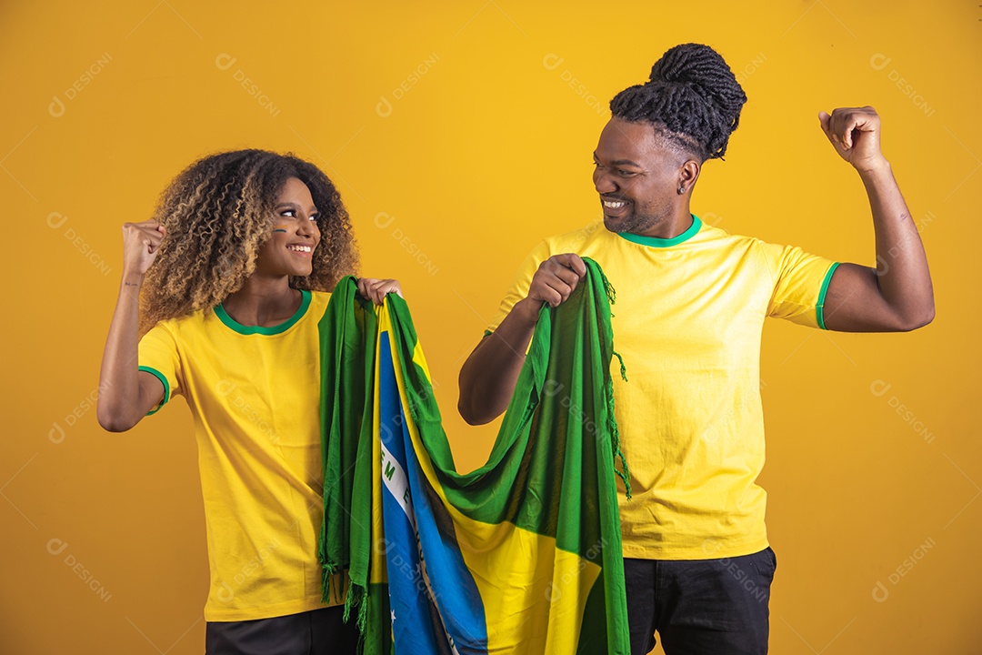 Casal afro-brasileiro segurando a bandeira do Brasil