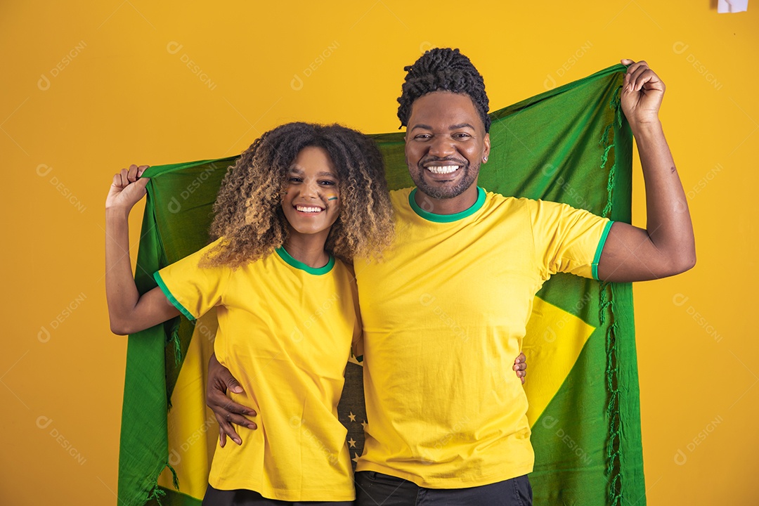 Casal afro-brasileiro segurando a bandeira do Brasil