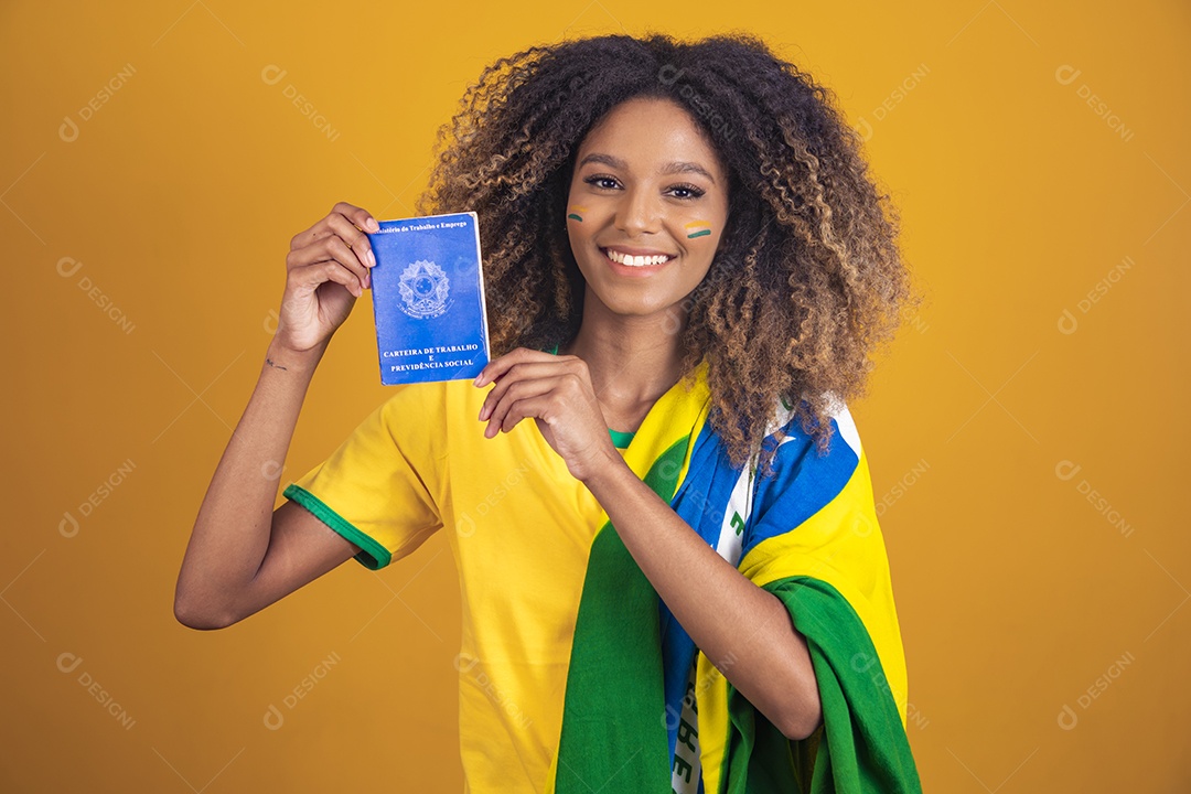 Mulher afro-brasileira vestindo camiseta do Brasil segurando uma carteira de trabalho