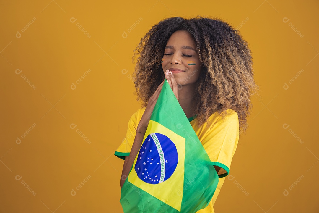 Mulher afro-brasileira segurando a bandeira do Brasil