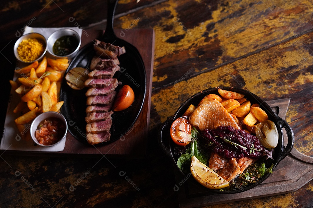 Delicioso churrasco com batatas e molho vinagrete sobre mesa de madeira