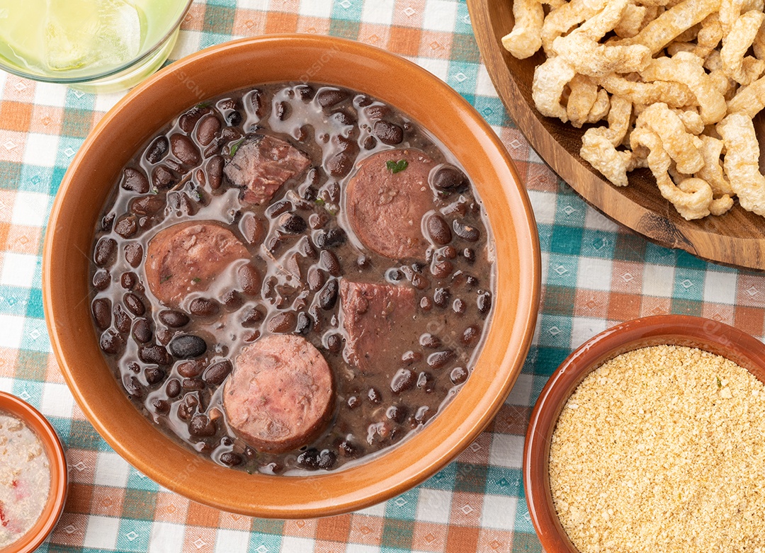 Feijoada típica brasileira com couve, arroz e farofa.