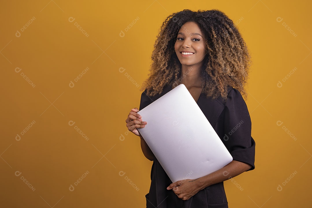 Mulher afro-brasileira vestida formalmente segurando um notebook