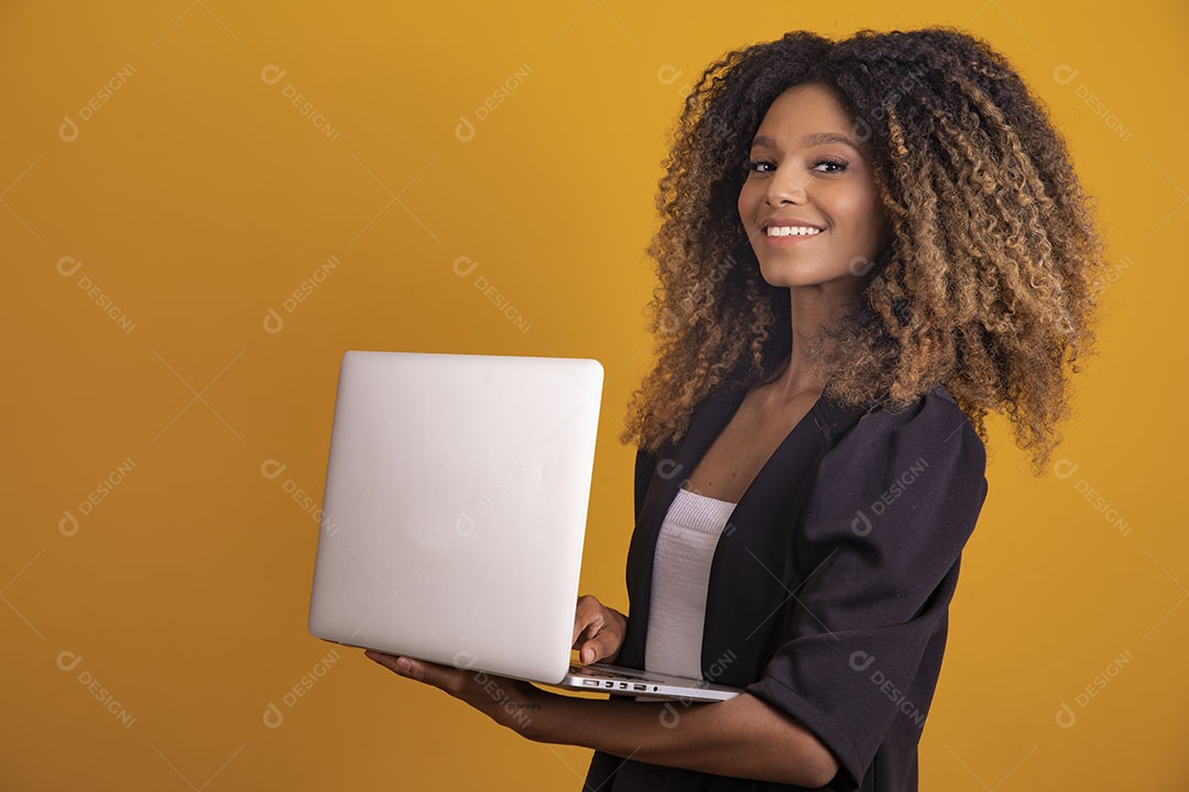 Mulher afro-brasileira vestida formalmente segurando um notebook