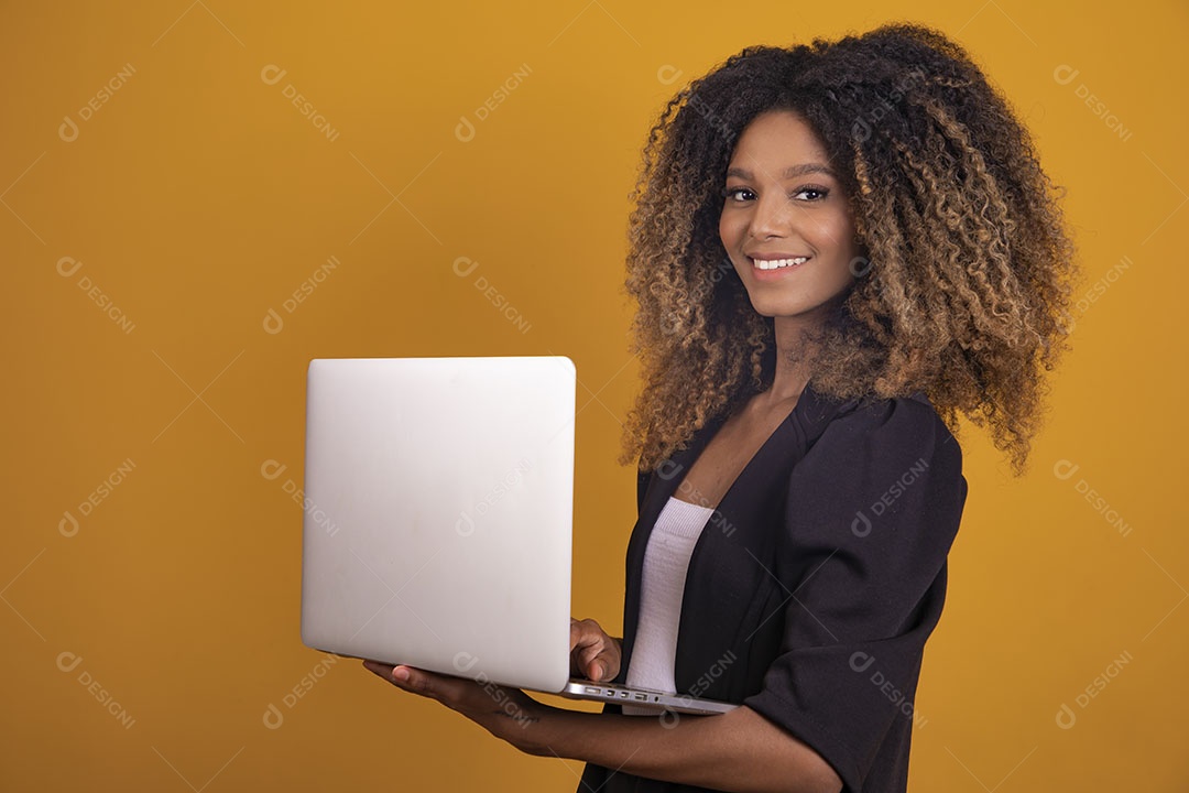 Mulher afro-brasileira vestida formalmente segurando um notebook