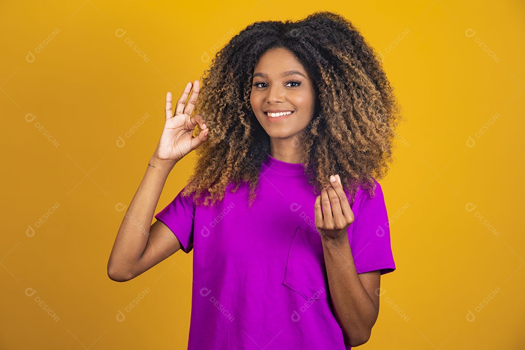 Mulher afro-brasileira usando camiseta roxa fazendo gestos