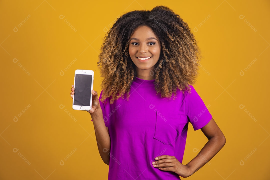 Mulher afro-brasileira usando camiseta roxa segurando um celular