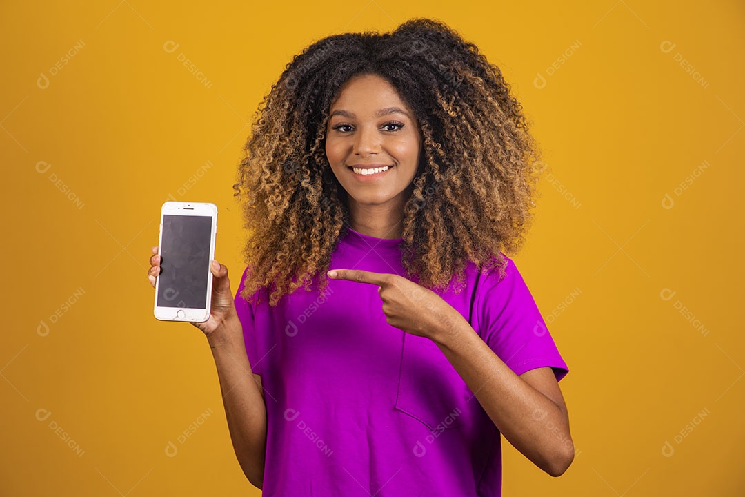 Mulher afro-brasileira usando camiseta roxa segurando um celular
