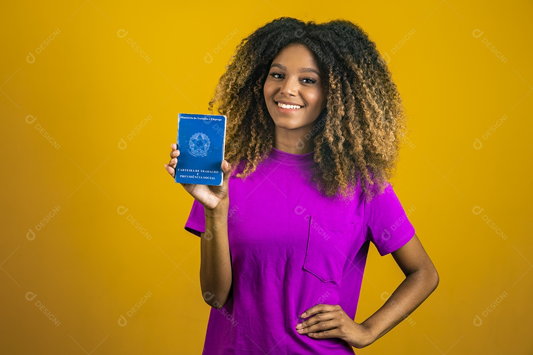 Linda mulher jovem morena cabelo afro segurando carteira de trabalho sobre fundo isolado amarelo