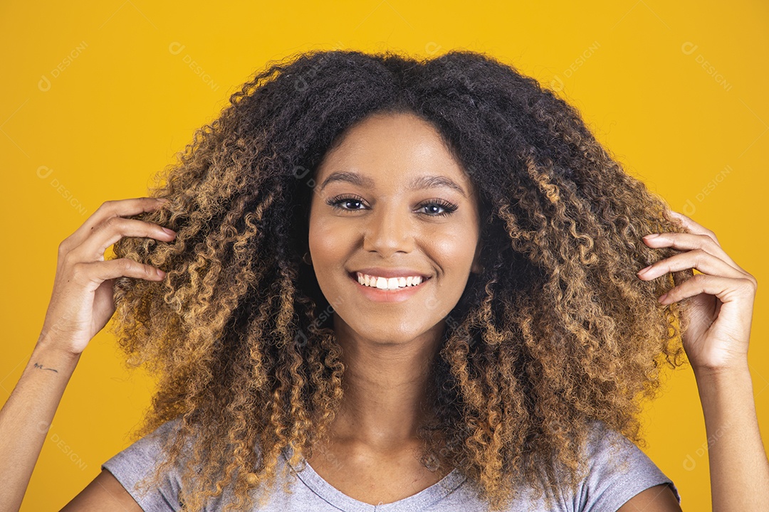 Linda mulher jovem morena cabelo afro sobre fundo isolado amarelo