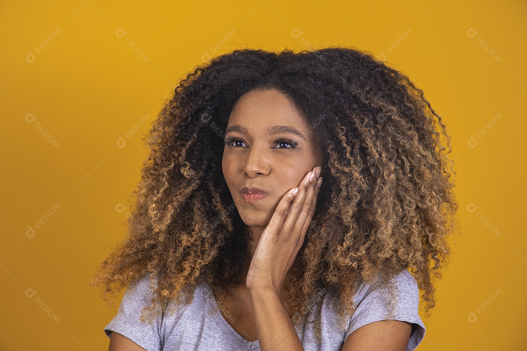 Linda mulher jovem morena cabelo afro sobre fundo isolado amarelo