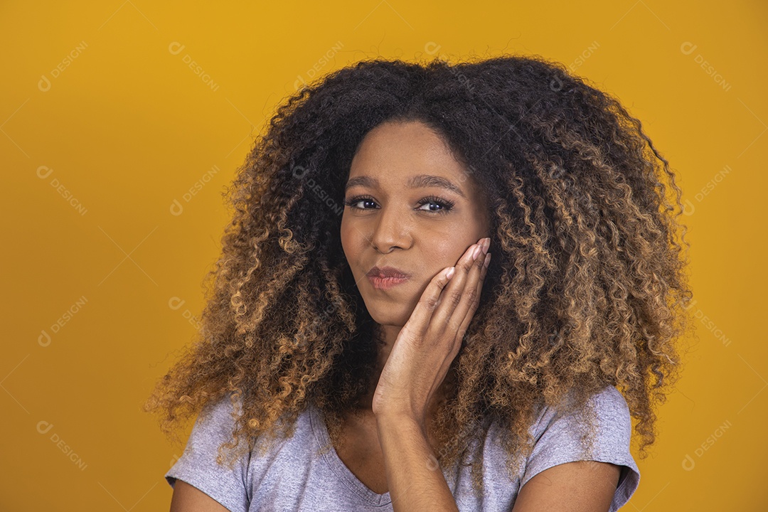 Linda mulher jovem morena cabelo afro sobre fundo isolado amarelo