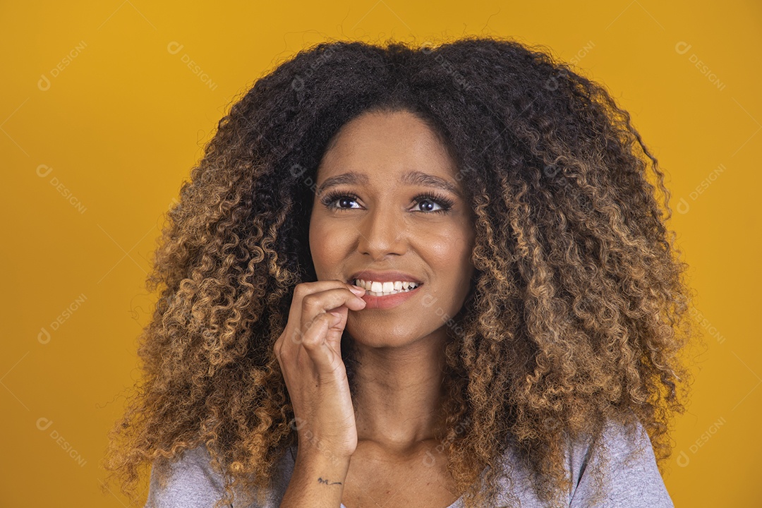 Linda mulher jovem morena cabelo afro sobre fundo isolado amarelo